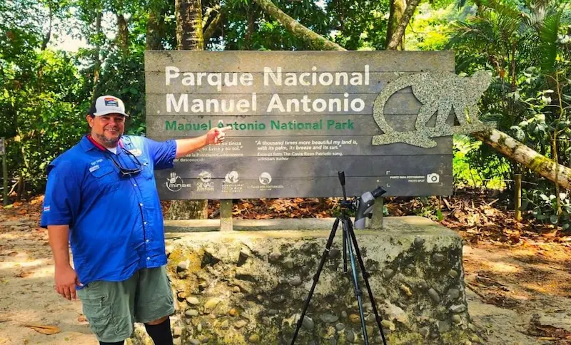 Guía experto mostrando un perezoso con telescopio en el tour del Parque Nacional Manuel Antonio con transporte incluido.